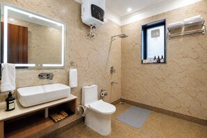 A bathroom with a large mirror, a sink, a toilet, a shower, and a towel rack. - ELIVAAS Panchvati Veloraa 6BHK (Solan)