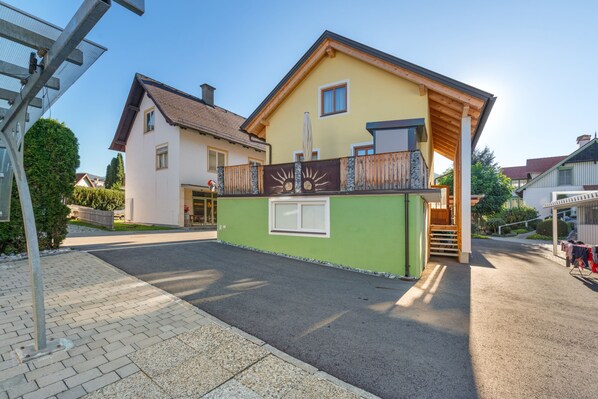 A two-story building with a green facade and a wooden balcony.