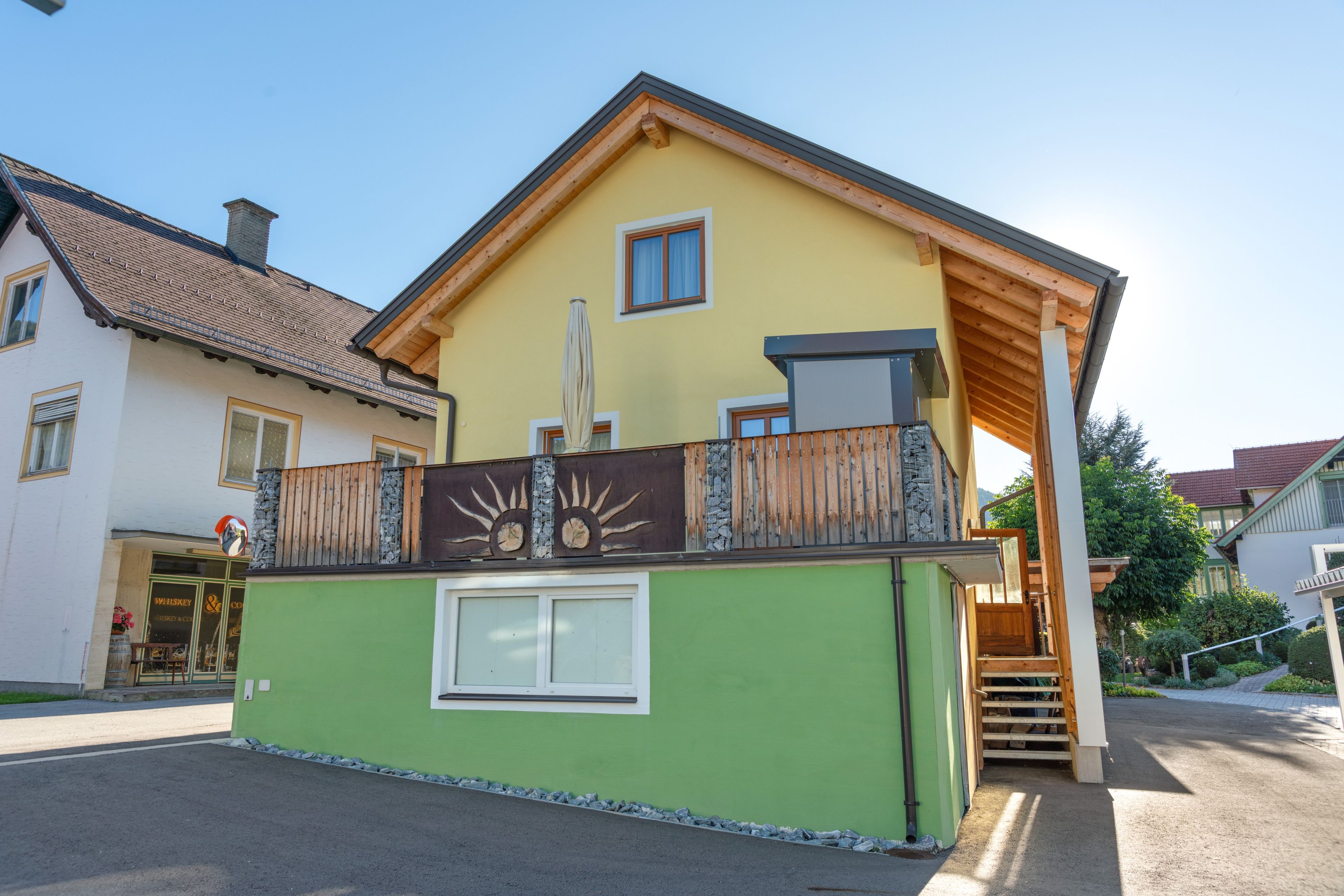 A two-story house with a balcony, a chimney, and a window.