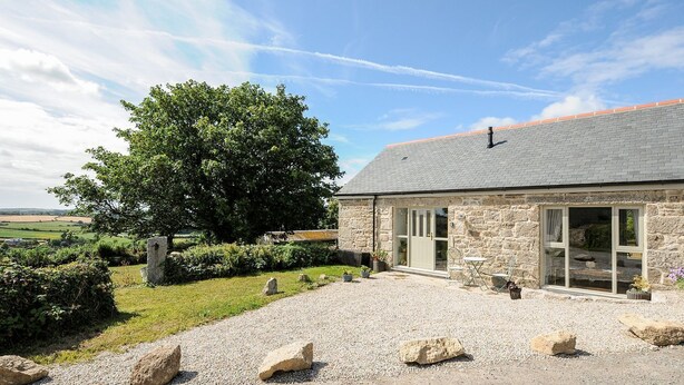 A stone building with a gravel driveway, a large tree, and a clear sky. - The Forge (Falmouth)