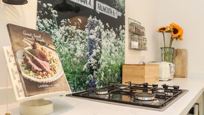 A kitchen with a gas stove, a framed menu, and a wall with a street sign. - The Forge (Falmouth)
