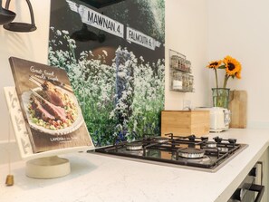 Eine Küche mit Gasherd, einem gerahmten Menü und einer Wand mit einem Straßenschild.