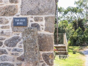 Un mur de pierres sur lequel est apposée une plaque indiquant : « THE OLD BYRE ».