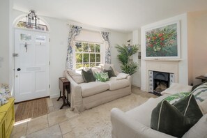 Ein Wohnzimmer mit einem weißen Sofa, einem Kamin und einem Gemälde an der Wand.