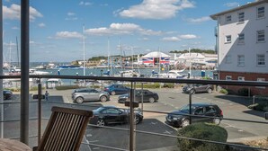Ein Yachthafen mit Booten, einer britischen Flagge und einem Gebäude mit roter und weißer Fassade.