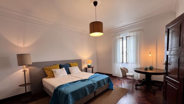 Una habitación de hotel con cama, mesitas de noche, escritorio y una silla.