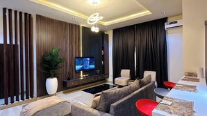 Una sala de estar moderna con un sofá, televisor y sillones rojos.