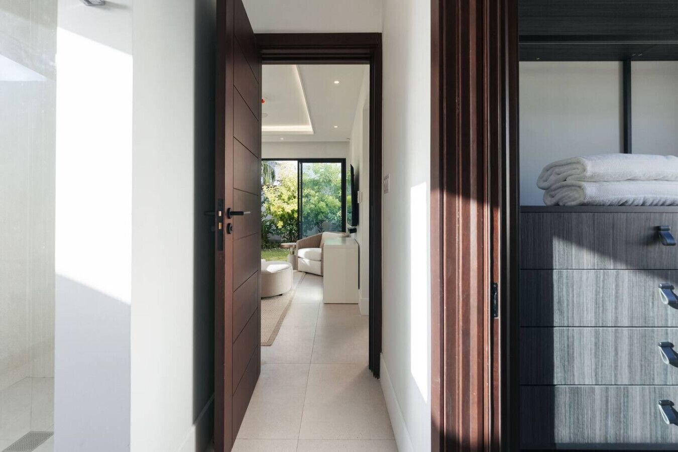 Quarto de hotel moderno com uma cama grande, um closet espaçoso e vista para o exterior.