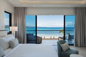 A hotel room with a large bed, a chair, a small table, and a balcony with a view of the ocean. - Bocobay Palm Beach Villas (St. Anns Bay)