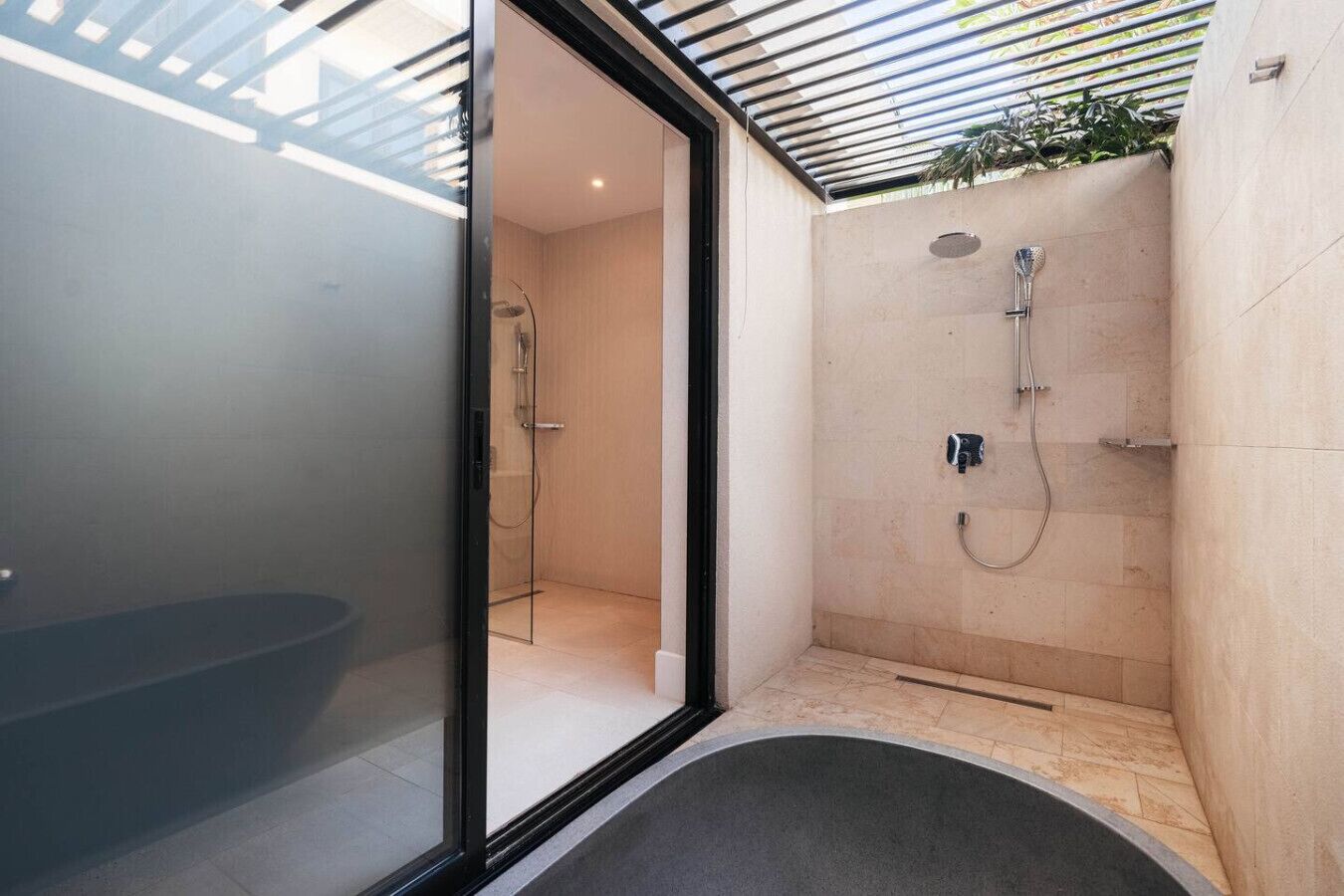 A modern bathroom with a glass door, a shower, and a bathtub.