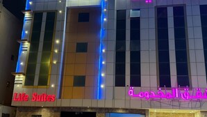 A hotel with a modern facade, featuring illuminated signage in multiple languages, including Arabic and English. - Life Suites Serviced Apartments (Riyadh)