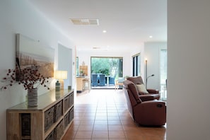 Ein modernes Wohnzimmer mit einer Couch, einem Essbereich und Blick ins Freie.