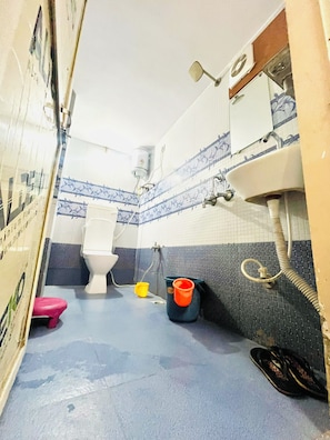 A bathroom with a toilet, sink, and shower.