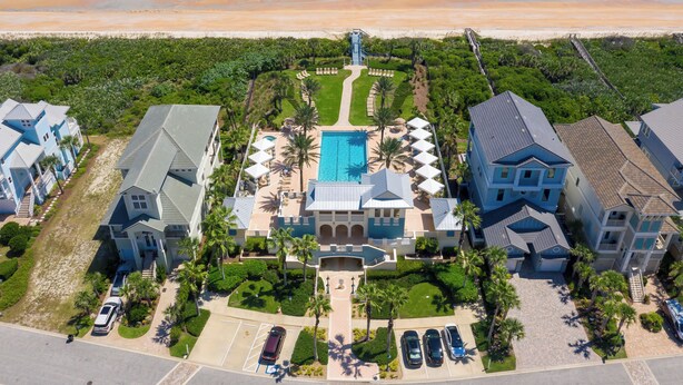 Un resort con piscina, acceso a la playa y varias edificaciones.
