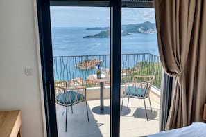 A balcony with a table, chairs, and a bottle. - Quercus Villa 2 (Tudorovići)