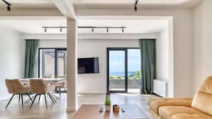 Un salon moderne comprenant un canapé, une table basse et un coin repas avec des chaises et une table.