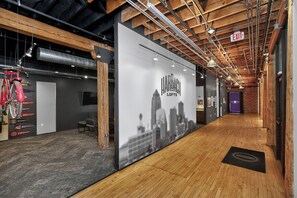 A hallway with a Harbach Lofts sign, wooden beams, and a black and white cityscape mural. - Top Floor Loft l Downtown Views l Free Parking l Pet Friendly (Des Moines)
