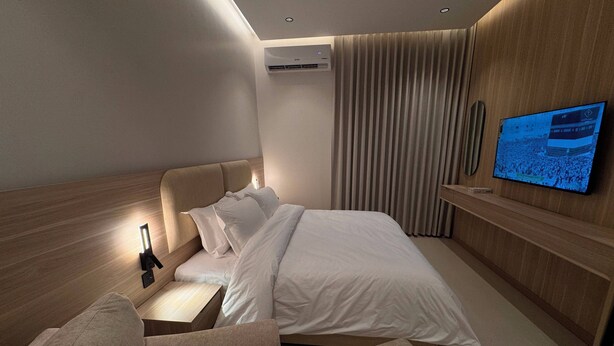 A modern hotel room with a bed, a TV, a desk, and a sofa. - RAMA Dubai Serviced Apartments 3 Granada (Riyadh)