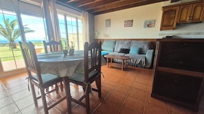 A dining area with a table and chairs, a sofa, and a kitchen area with cabinets.