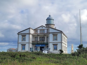 A large, historic building with a prominent lighthouse tower, a balcony, and a sign reading 'Medio Marinho de Peniche.'