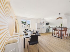 Eine moderne Küche mit Essbereich, einem großen Fenster und Blick ins Freie.