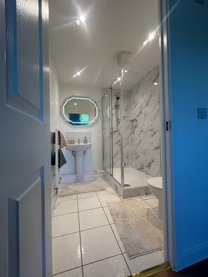 Een douche, handdoeken, zeep, toiletpapier