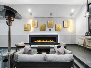 Uma sala de estar moderna com lareira, um sofá e obras de arte penduradas na parede.
