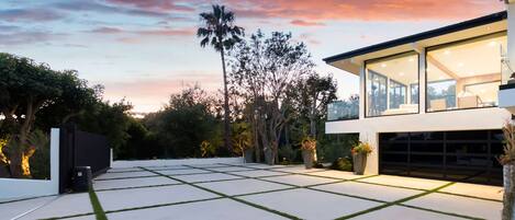 A modern house with a spacious patio, large windows, and a garage.