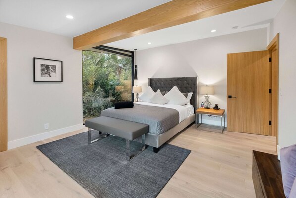 A modern bedroom with a large bed, a bench, a bedside table, and a wardrobe. - Sea Vista (Malibu)