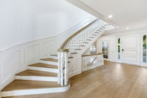 A grand staircase with white balustrades and wooden steps leading to an upper floor. - Emerson Estate (Sherman Oaks)