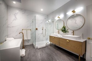 A modern bathroom with a bathtub, a walk-in shower, and a vanity with two sinks. - Reef Mall (Marina del Rey)