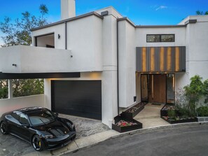 A modern two-story house with a black car parked in front. - Franklin Modern (West Hollywood)