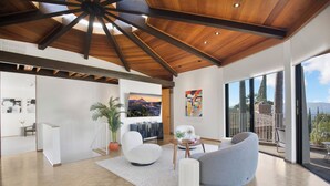 Un amplio espacio habitable con techo alto, un ventanal y vistas al exterior.