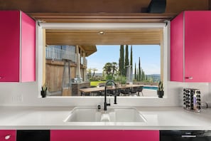A kitchen with a large window, a sink, and a Bosch dishwasher. - Via Vallarta (Encino)