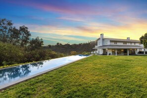 A large, white house with a pool and a covered patio area. - Stradella Hideaway (Los Angeles)