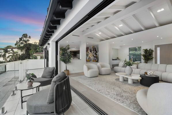 A modern outdoor living space with a sofa set, chairs, and a dining area.