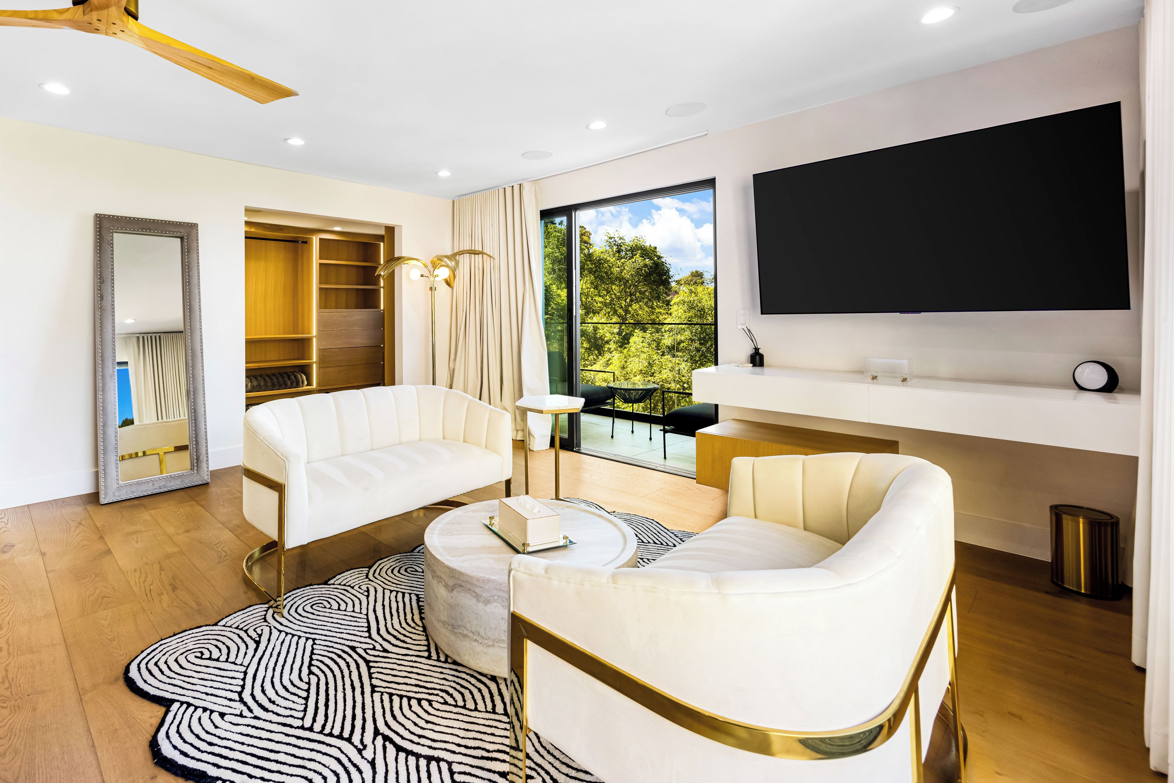 A modern living room with a sofa, a coffee table, and a TV mounted on the wall.