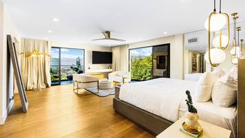 Quarto de hotel moderno com uma cama grande, uma escrivaninha, uma cadeira e vista para o exterior.