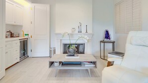A modern living room with a fireplace, white furniture, and a coffee table. - Carolwood Estate (Beverly Hills)