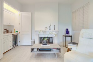 Ein modernes Wohnzimmer mit Kamin, weißen Möbeln und einem Couchtisch.