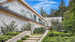 A modern house with a white exterior, wooden beams, and a glass facade. - Laurel Canyon (Los Angeles)