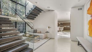 A modern interior with a staircase, a sofa, a coffee table, and a dining area. - Laurel Canyon (Los Angeles)