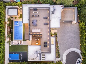 An aerial view of a modern house with a swimming pool, outdoor seating area, and a circular driveway. - Levitt Lane (Sherman Oaks)
