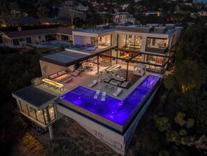 A modern two-story house with a rooftop pool, outdoor seating, and a large glass facade. - Collingwood (West Hollywood)