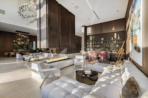 A modern living room with a fireplace, a bar area, and a large painting. - Collingwood (West Hollywood)