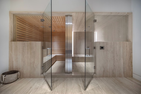 A modern bathroom with glass doors, wooden slats, and a marble floor. - Collingwood (West Hollywood)