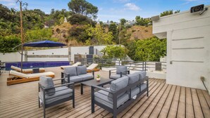 A rooftop patio with outdoor seating, a pool, and a view of a hillside. - Franklin Mediterranean Villa (West Hollywood)