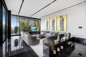 Una sala de estar moderna con un sofá grande, una mesa de centro y obras de arte en la pared.