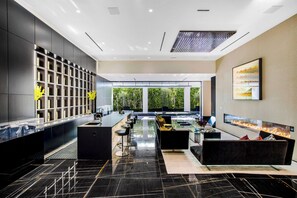 A modern kitchen with a black marble countertop, a built-in wine rack, and a large window overlooking a garden. - London Dream (West Hollywood)