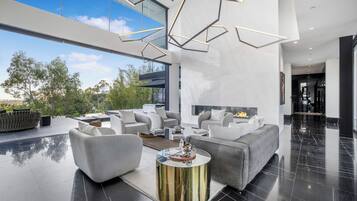 A modern living room with a large sofa, a coffee table, and a fireplace.